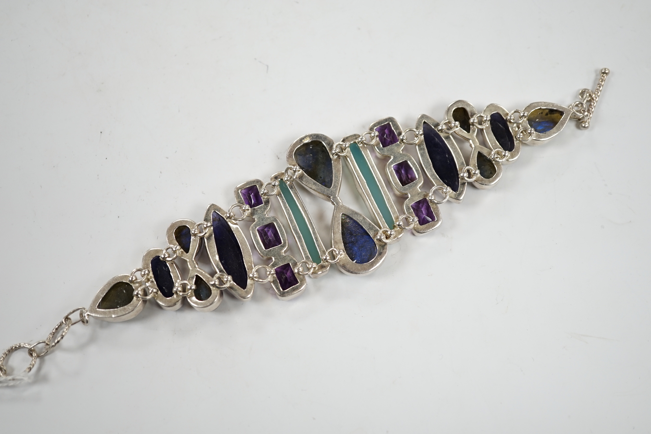 A white metal and multi gem set bracelet, including dyed agate, amethyst and labradorite, 21cm.